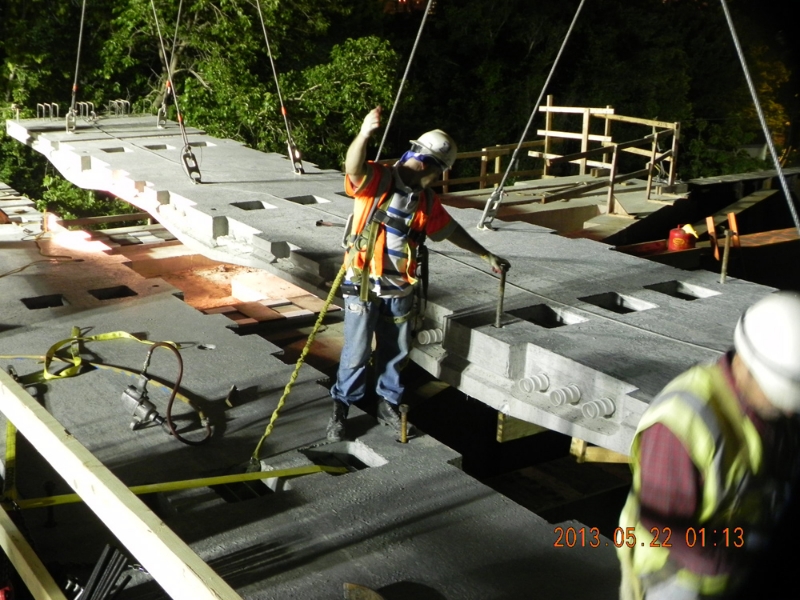 Installation of precast bridge deck panel over active rail lines during New York Avenue Bridge replacement in Washington, D.C.