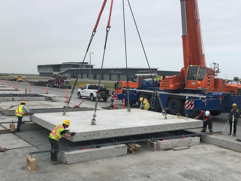 construction workers lowering super-slab concrete into place