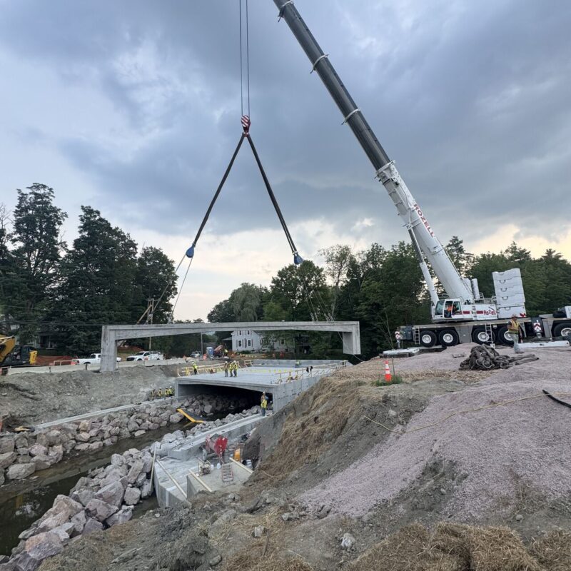 Crews installing precast rigid frame bridge components